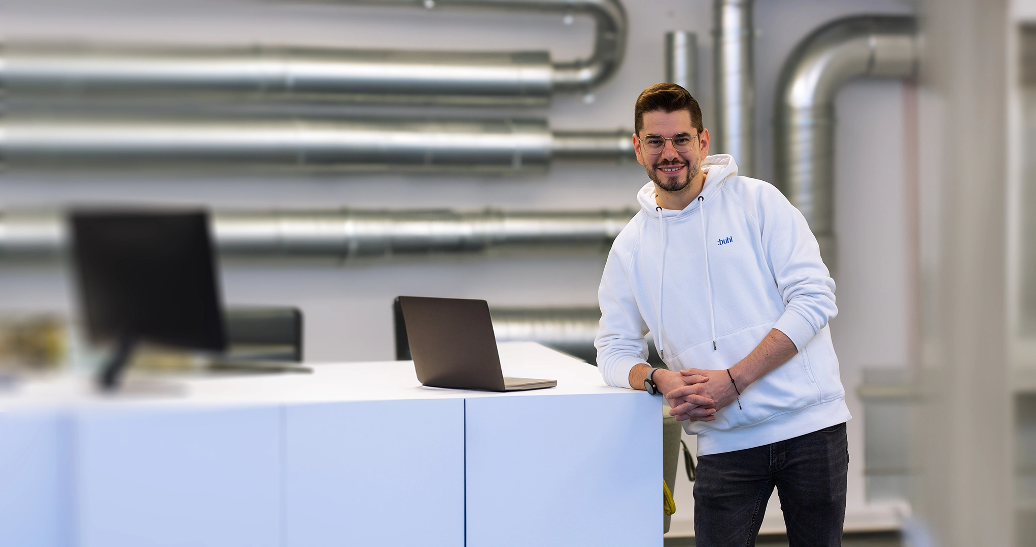 Mitarbeiter am Laptop in modernem Büro – steht für persönlichen Premium-Support